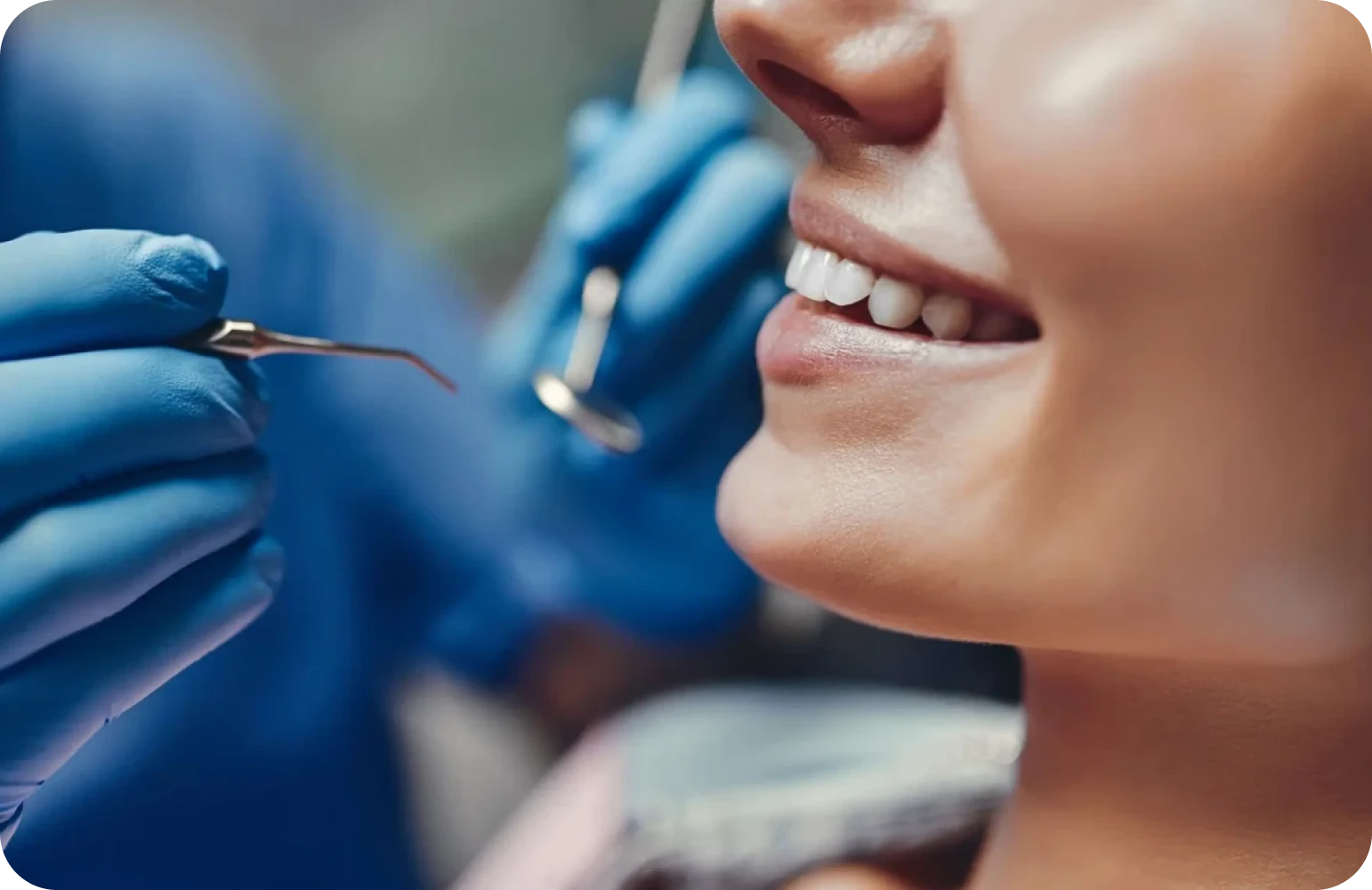 Patiente souriante examinée au miroir et à la sonde
